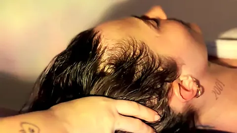 Massage du cuir chevelu dans une lumière chaude au salon Atelier Kora