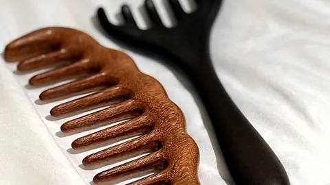 Peigne en bois et outil de massage posés sur la serviette, rituel Évasion